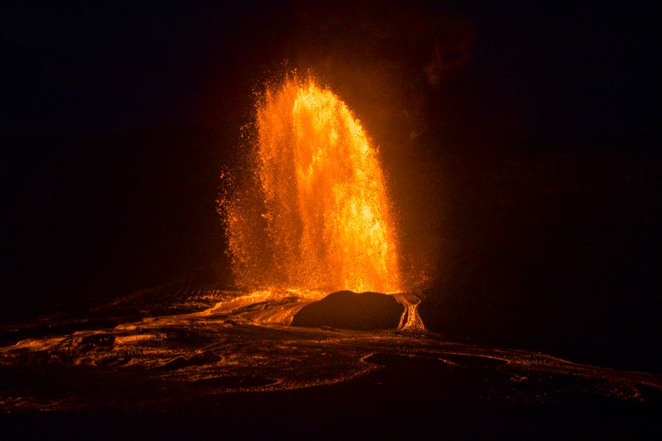 Stunning night capture of a fiery volcanic eruption in Hawaii with glowing lava.