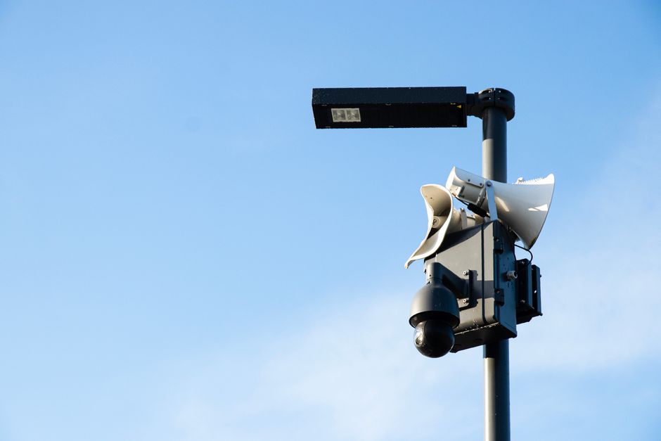 Street lamp post with security camera and speakers under a blue sky in Jūrmala, Latvia.